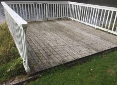 Förebild på sliten träaltan vid vattnet – gammal konstruktion innan renovering.
