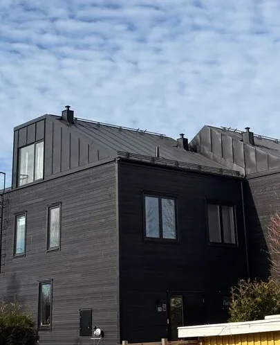 Svart plåttak på svarta nyproducerade parhus